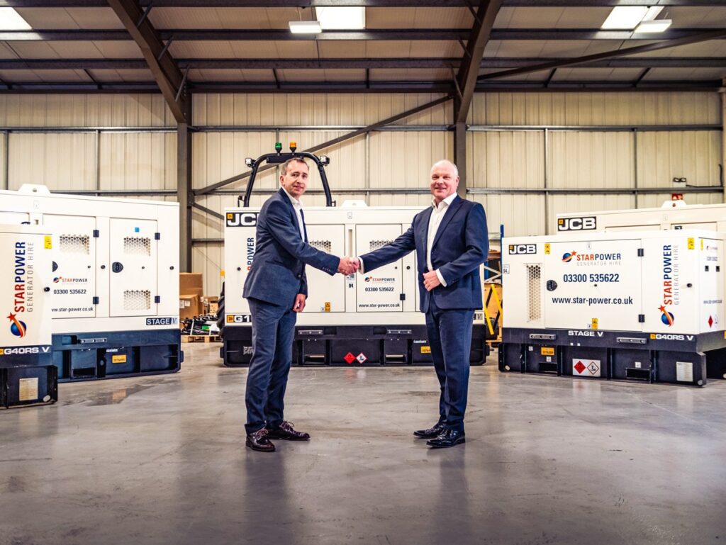Two men shake hands next to 3 Star Power JCB generators