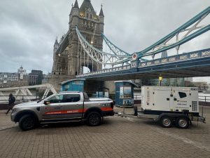 A Star Power generator being towed by a truck in London under a bridge.